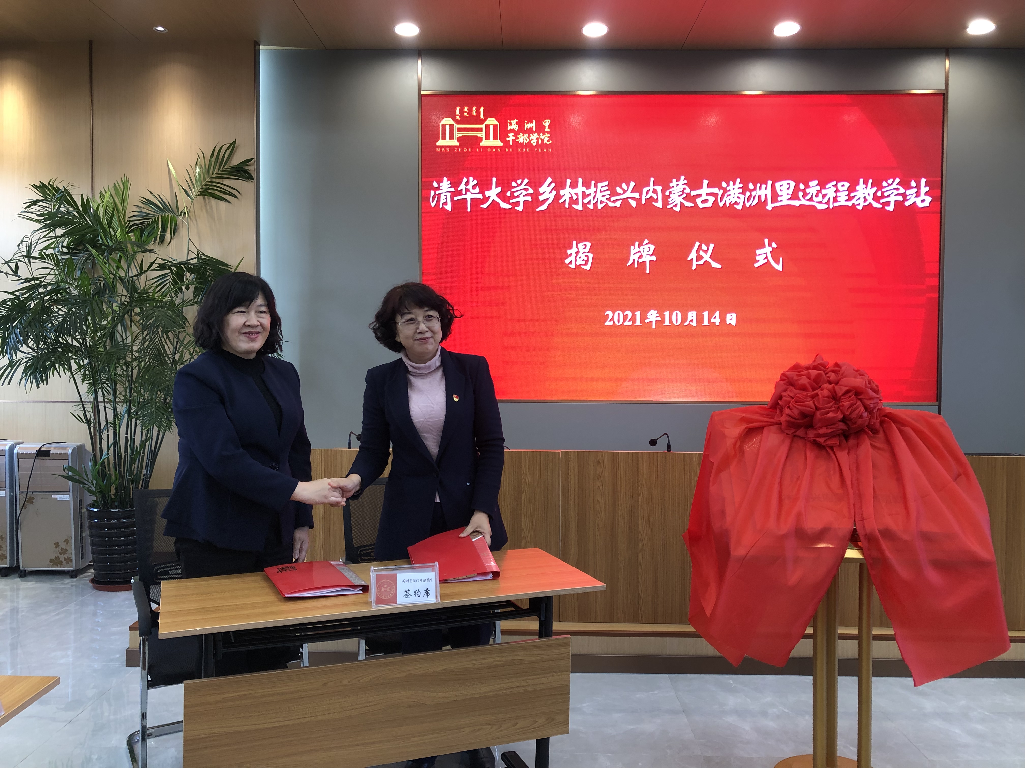 20211014-清华大学乡村振兴内蒙古满洲里远程教学站启动-供图:满洲里教学站-清华大学继续教育学院党委副书记、纪委书记 张文雪与满洲里市妇联主席张达签约《清华大学乡村振兴远程教学站合作协议》.jpg